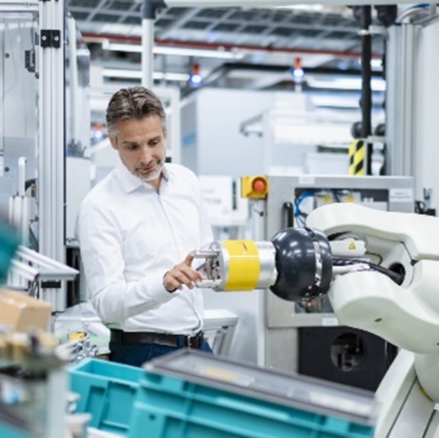 The picture shows a man inspecting the robot's sensor.